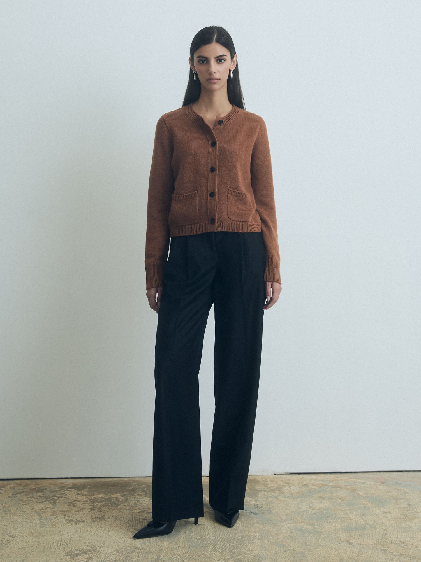Woman wearing Vicuna wool-cashmere blend cardigan with crew neck, button front, and two patch pockets by Judith & Charles.