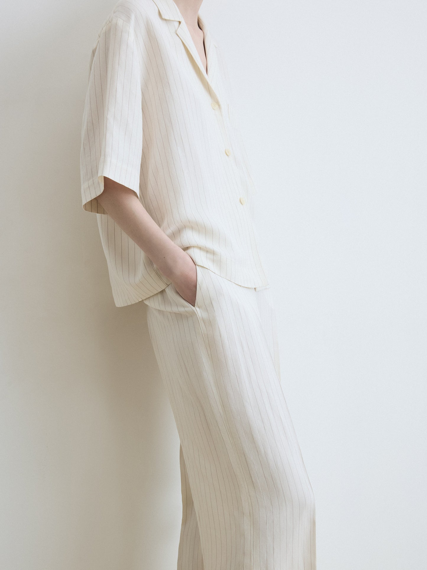 Person wearing a white outfit with a plain background