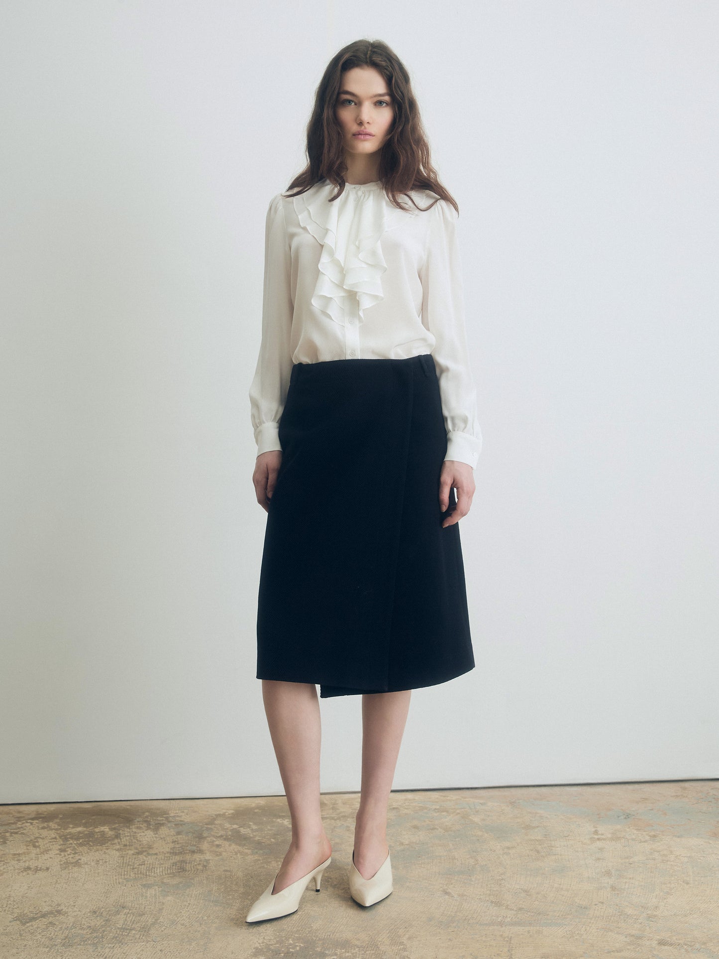 Silk ruffle blouse with stand collar, long sleeves, and double-layer ruffle detail, styled with a black skirt for an elegant look