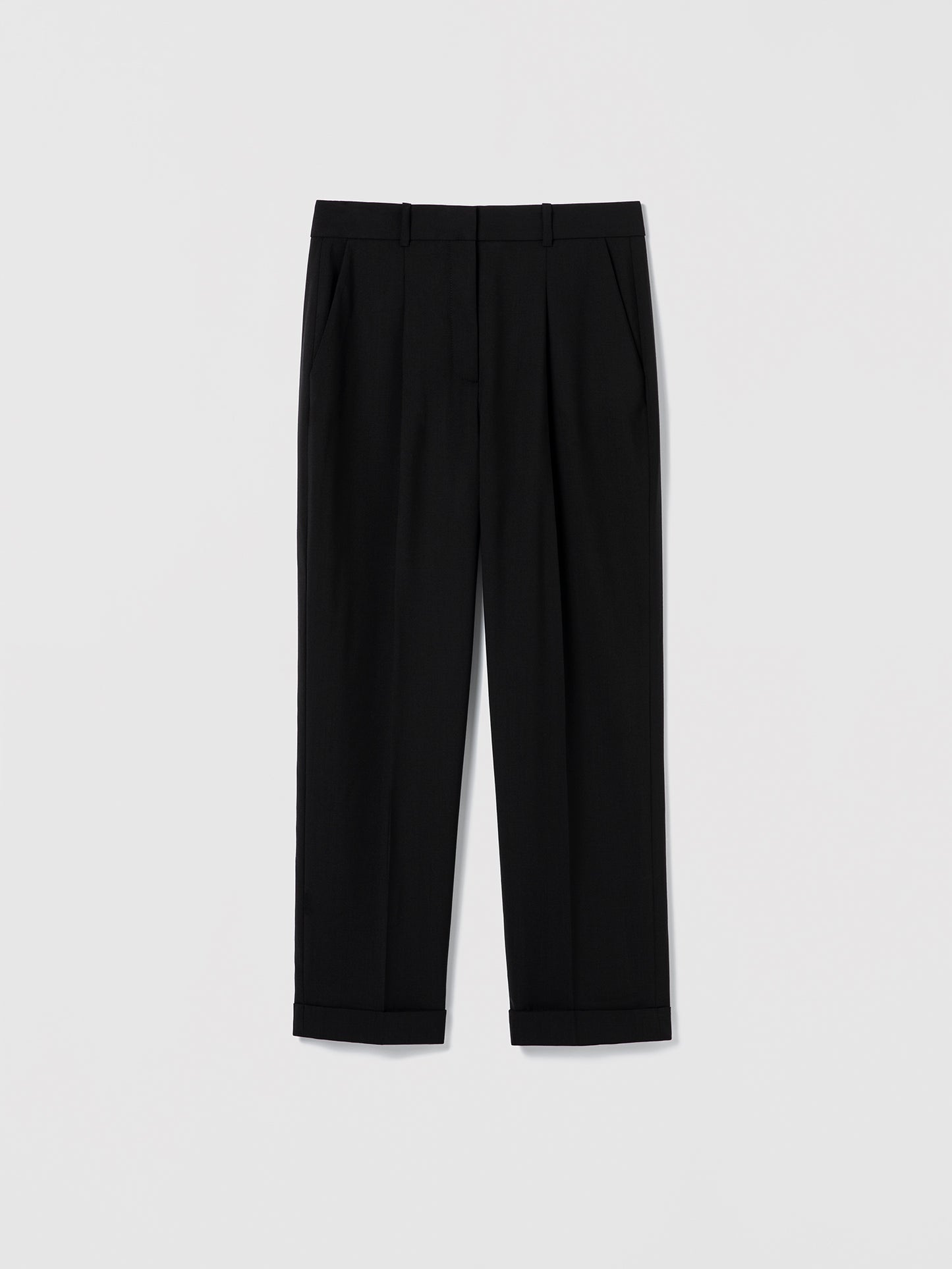 Flat‑lay of black pleated cuffed trousers with a clean tailored waistband, slash pockets, and back welt pockets