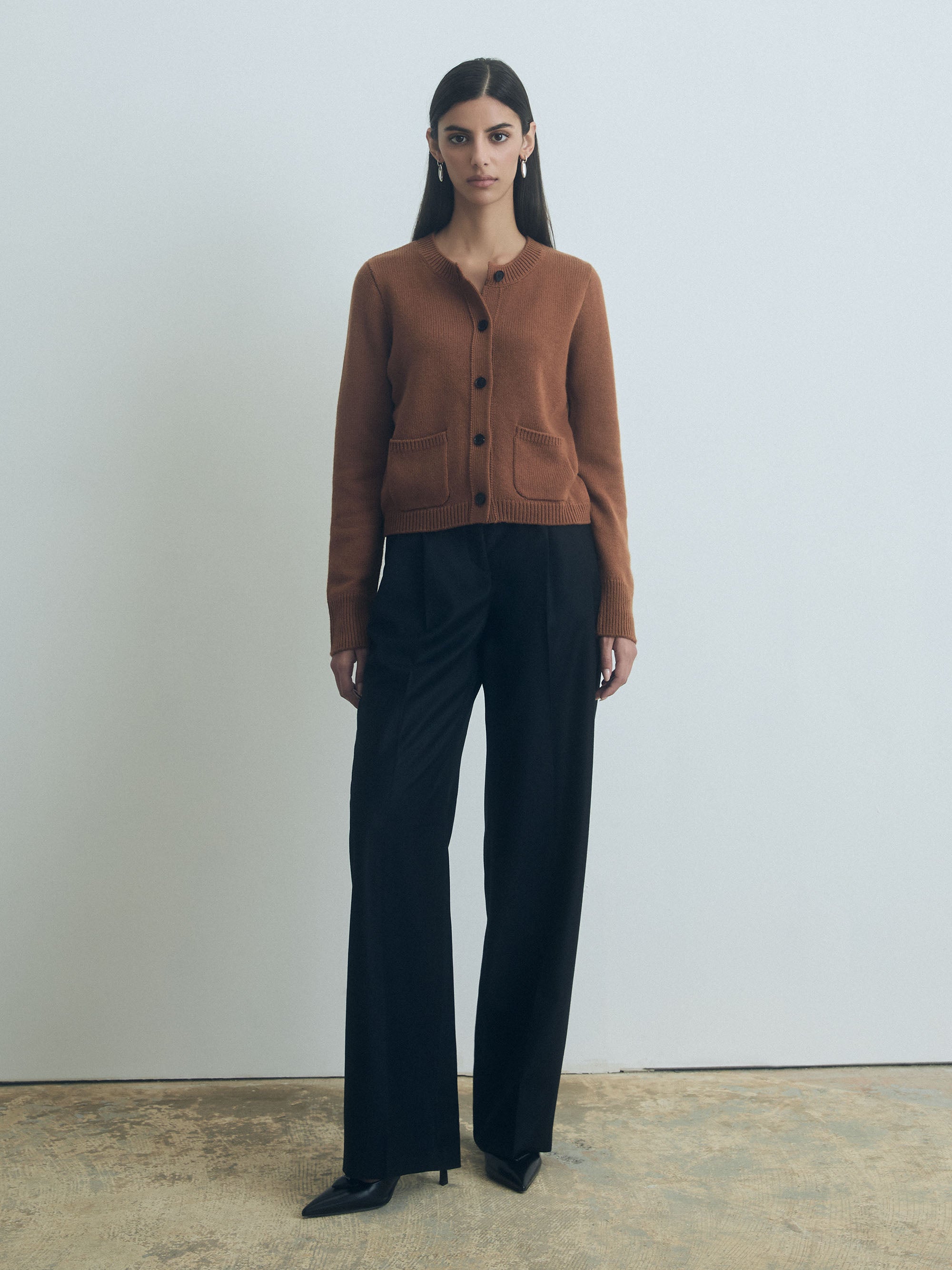 Woman wearing Vicuna wool-cashmere blend cardigan with crew neck, button front, and two patch pockets by Judith & Charles.
