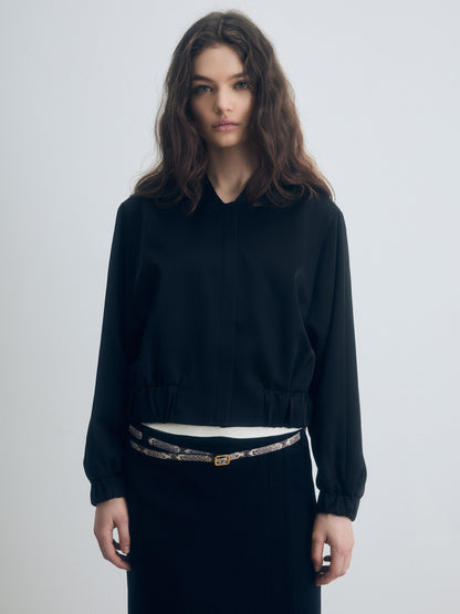 Black zip‑front jacket with elastic hem and cuffs, shown in a clean, structured silhouette.