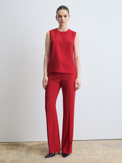 Woman wearing a red sleeveless top and red pants against a white background