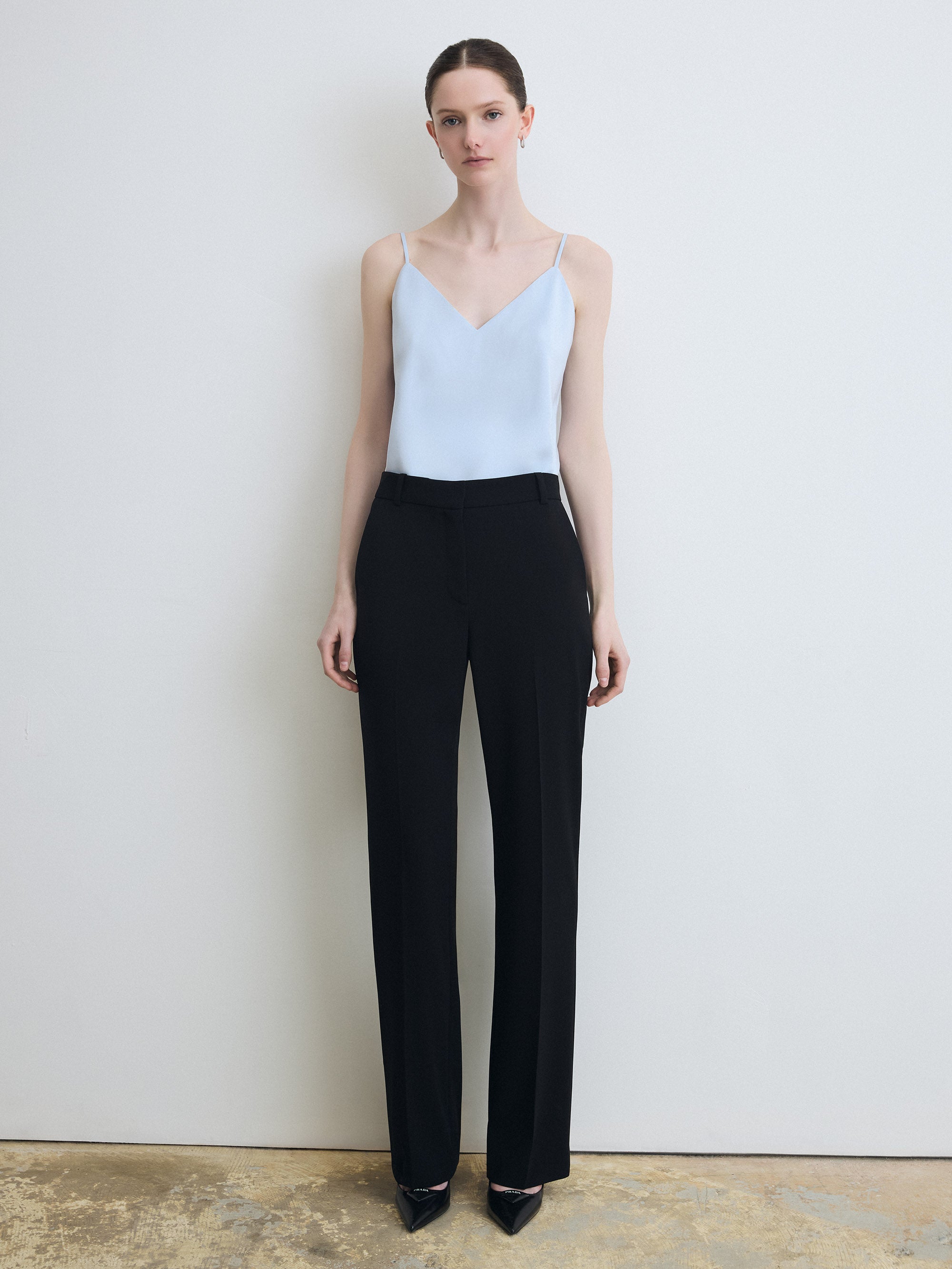 Model wearing sleeveless ice blue top paired with black pants