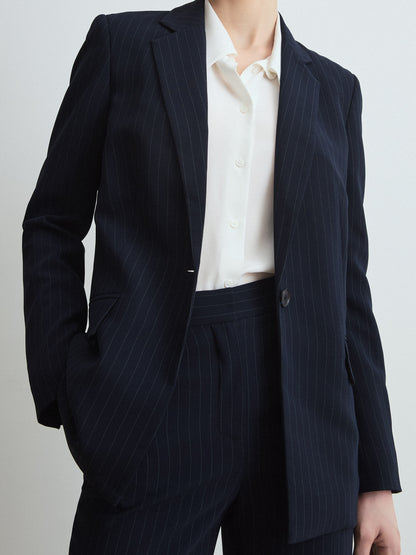 Navy pinstripe suit with white shirt on a plain background