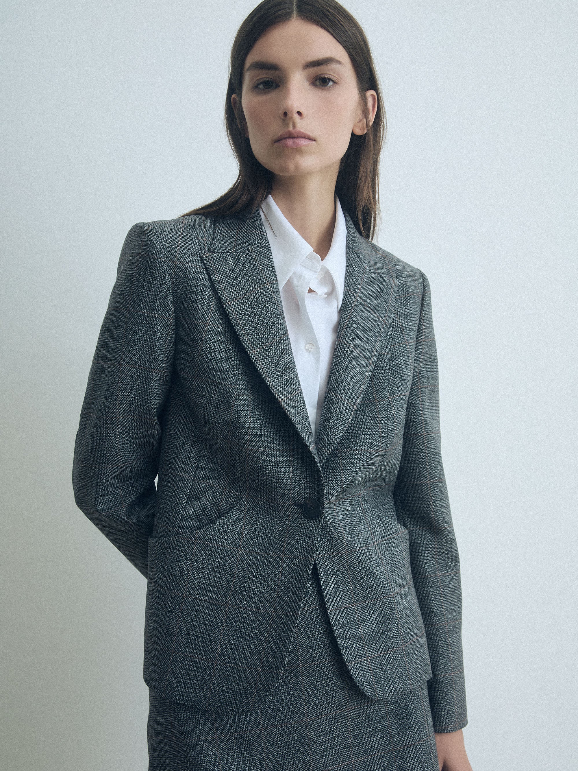Woman wearing Grey Prince of Wales check wool fitted single-breasted jacket by Judith & Charles.