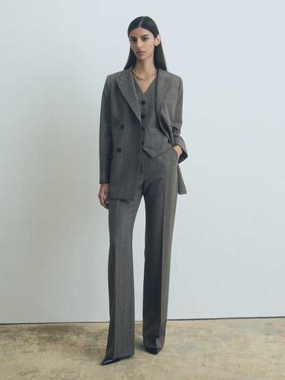 Model wearing Judith and Charles slight fit-to-flare herringbone wool pants with slash and back welt pockets, belt loops, unlined, made in Canada, taupe