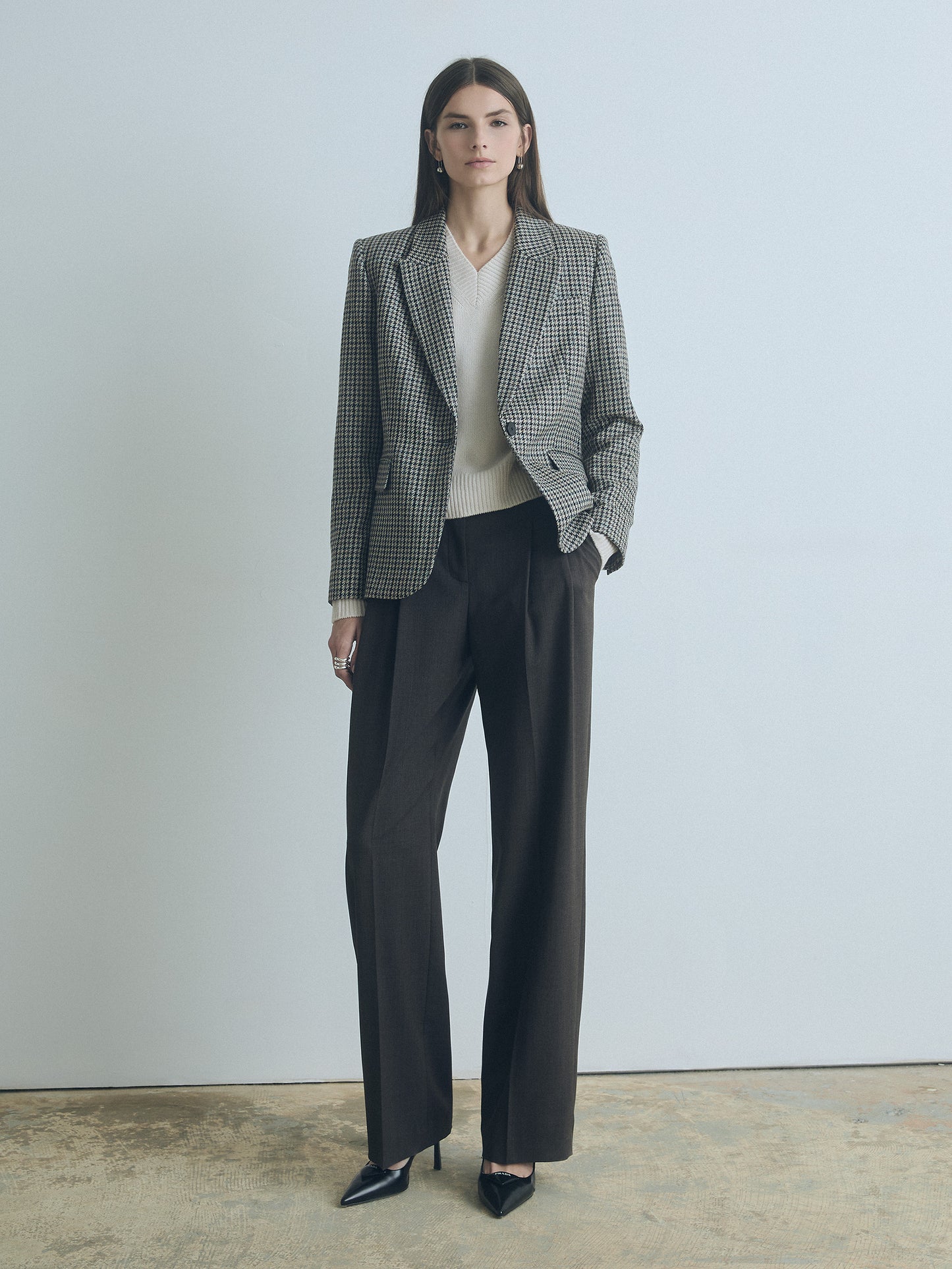 Woman wearing a judith and charles checkered taupe melange blazer and brown pants against a plain background