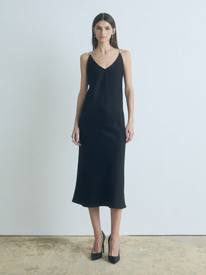 Model wearing black judith and charles Pearle satin bias slip dress with V-neck and shoulder embellishments