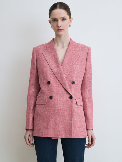 Woman wearing a red blazer with black buttons against a plain background