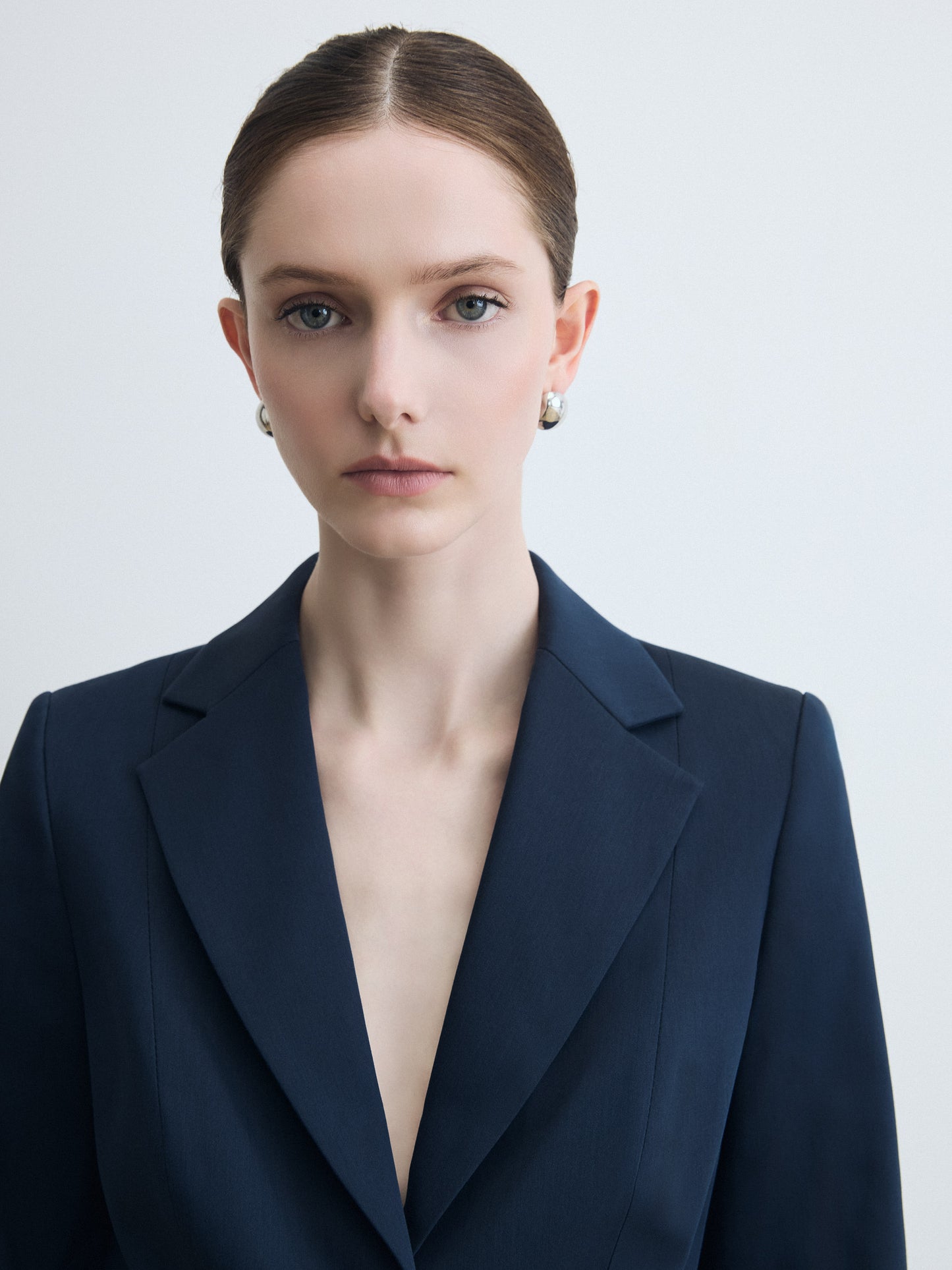 Woman wearing a dark blue blazer against a light background