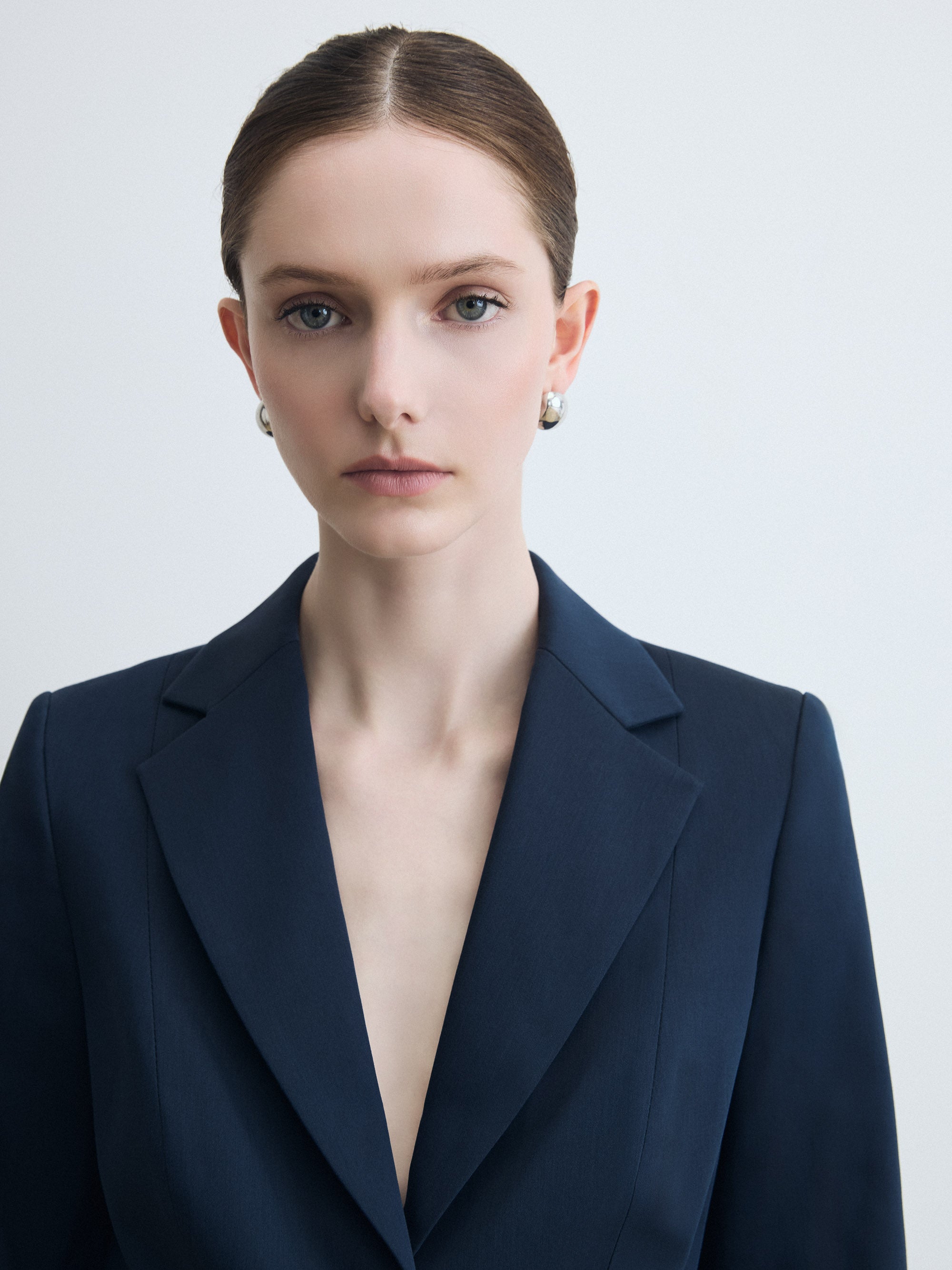 Woman wearing a dark blue blazer against a light background