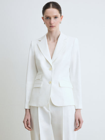 Woman wearing a white suit on a plain background
