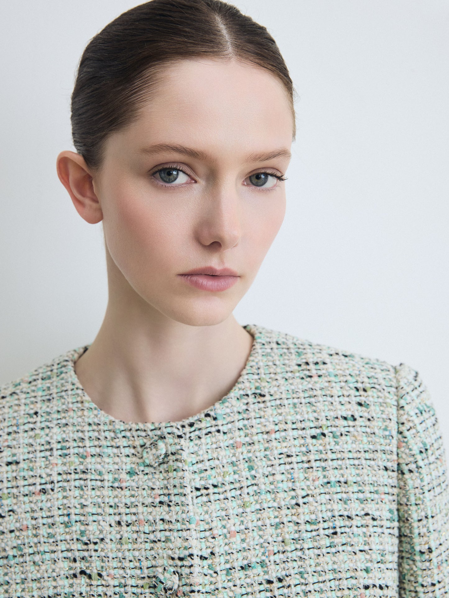 Woman wearing a textured jacket against a plain background