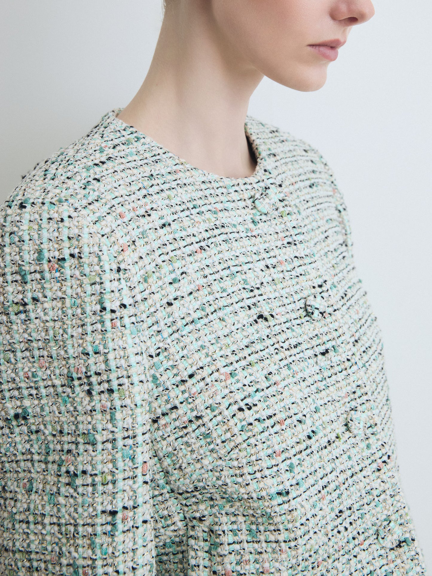 Close-up of a textured jacket worn by a person on a plain background