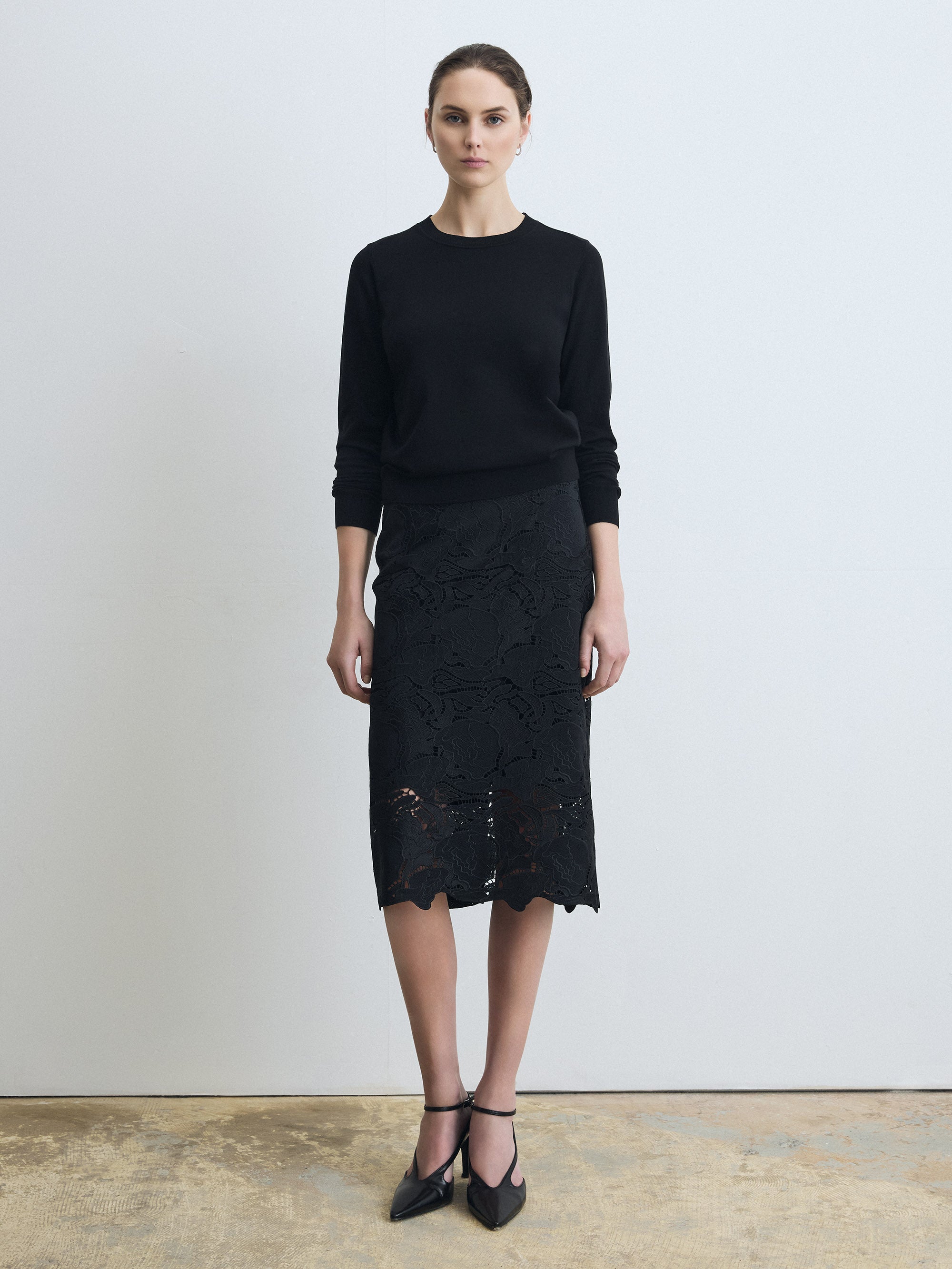 Woman wearing a clean, fully lined floral lace skirt  on a white background. 