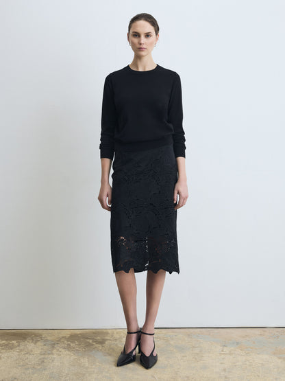 Woman wearing a clean, fully lined floral lace skirt  on a white background. 