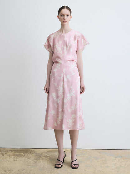 Woman wearing a pink floral dress against a plain background