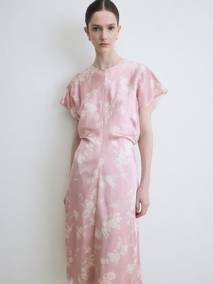 Woman wearing a pink floral dress against a white background