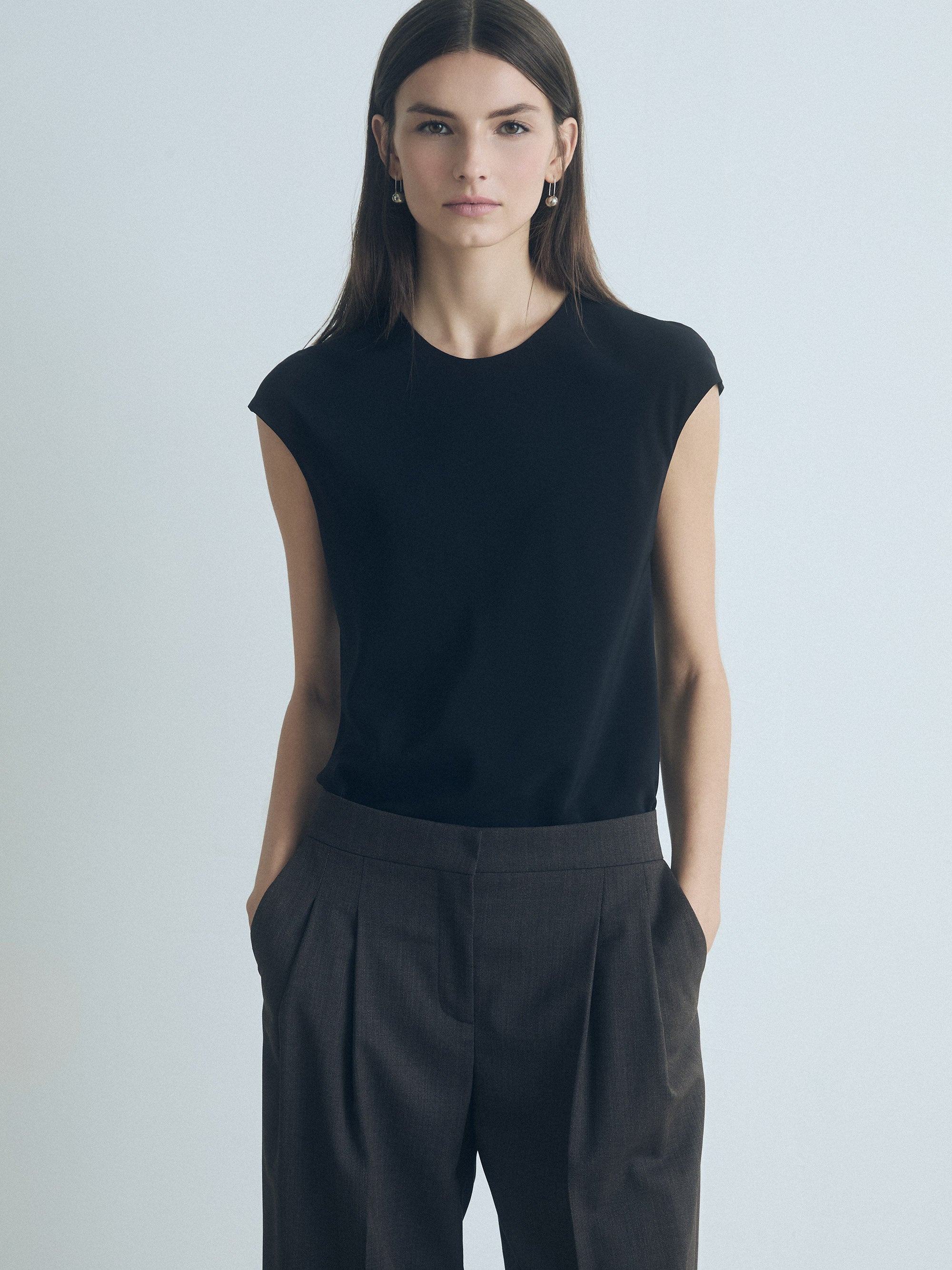 Woman wearing Judith & Charles black silk crew neck top — double-layer front, bias cut, back keyhole with button.