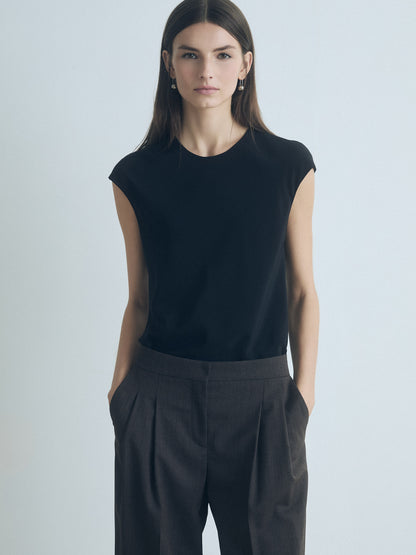 Woman wearing Judith & Charles black silk crew neck top — double-layer front, bias cut, back keyhole with button.
