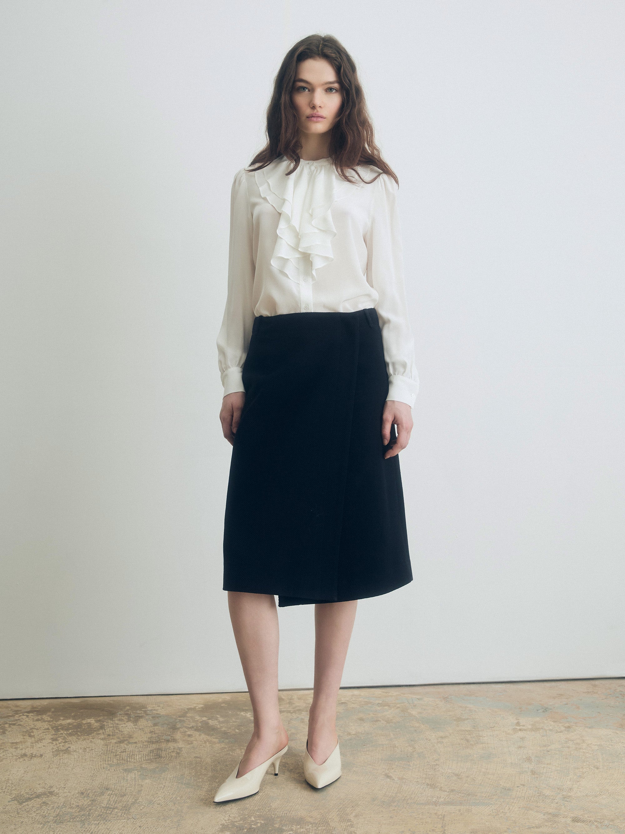 Silk ruffle blouse with stand collar, long sleeves, and double-layer ruffle detail, styled with a black skirt for an elegant look