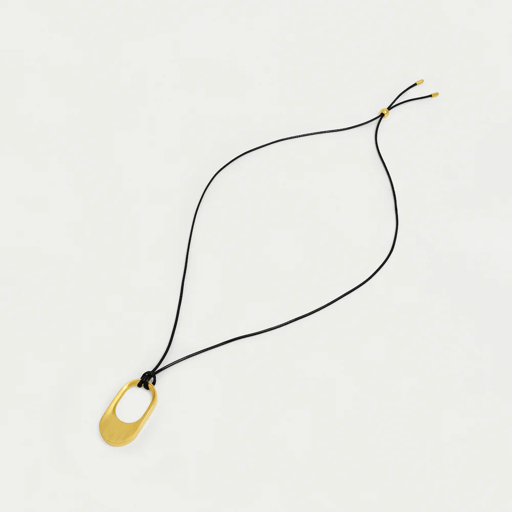 Necklace with a gold pendant on a black cord against a light gray background