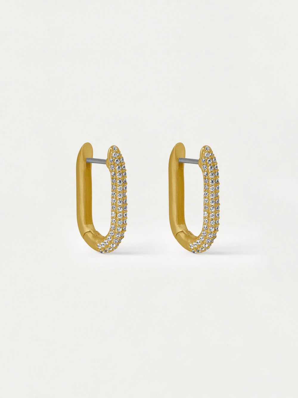 Gold hoop earrings with embedded stones on a light beige background