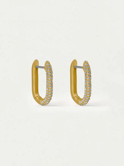 Gold hoop earrings with embedded stones on a light beige background