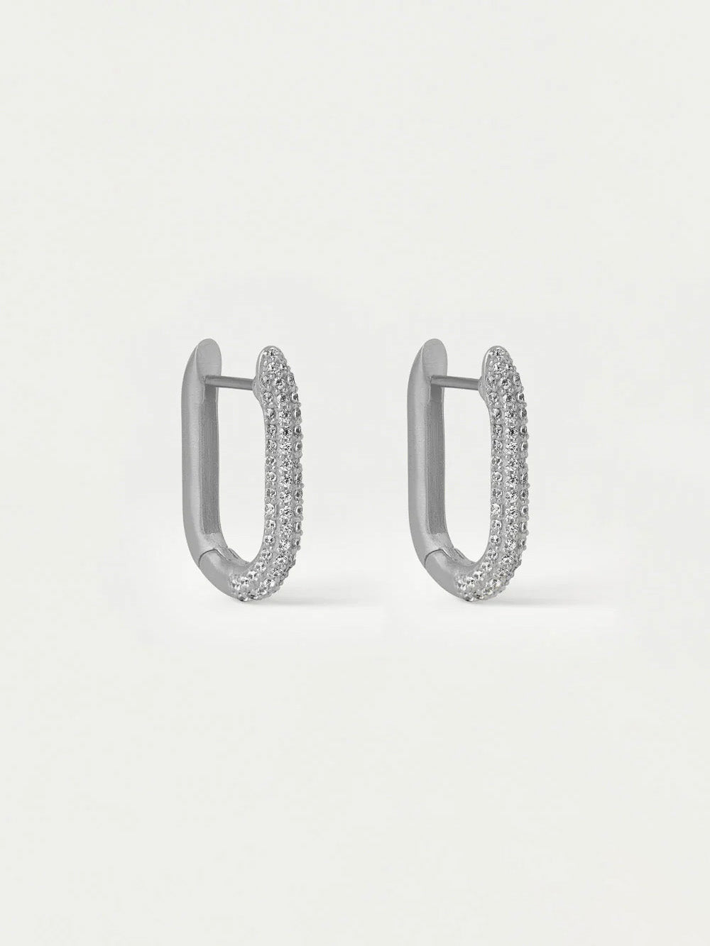 Pair of silver hoop earrings with embedded stones on a light gray background