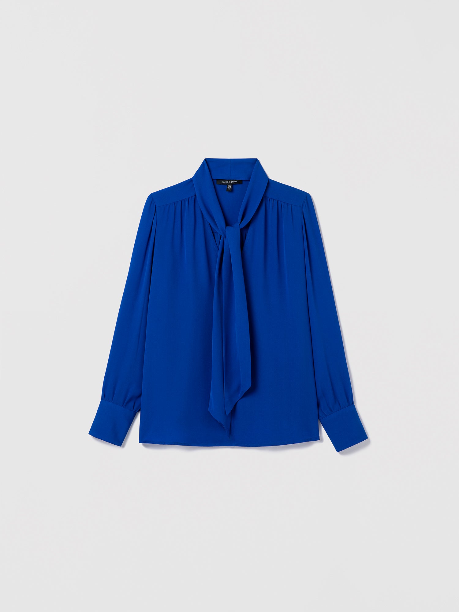Blue blouse with a tie neckline on a light gray background