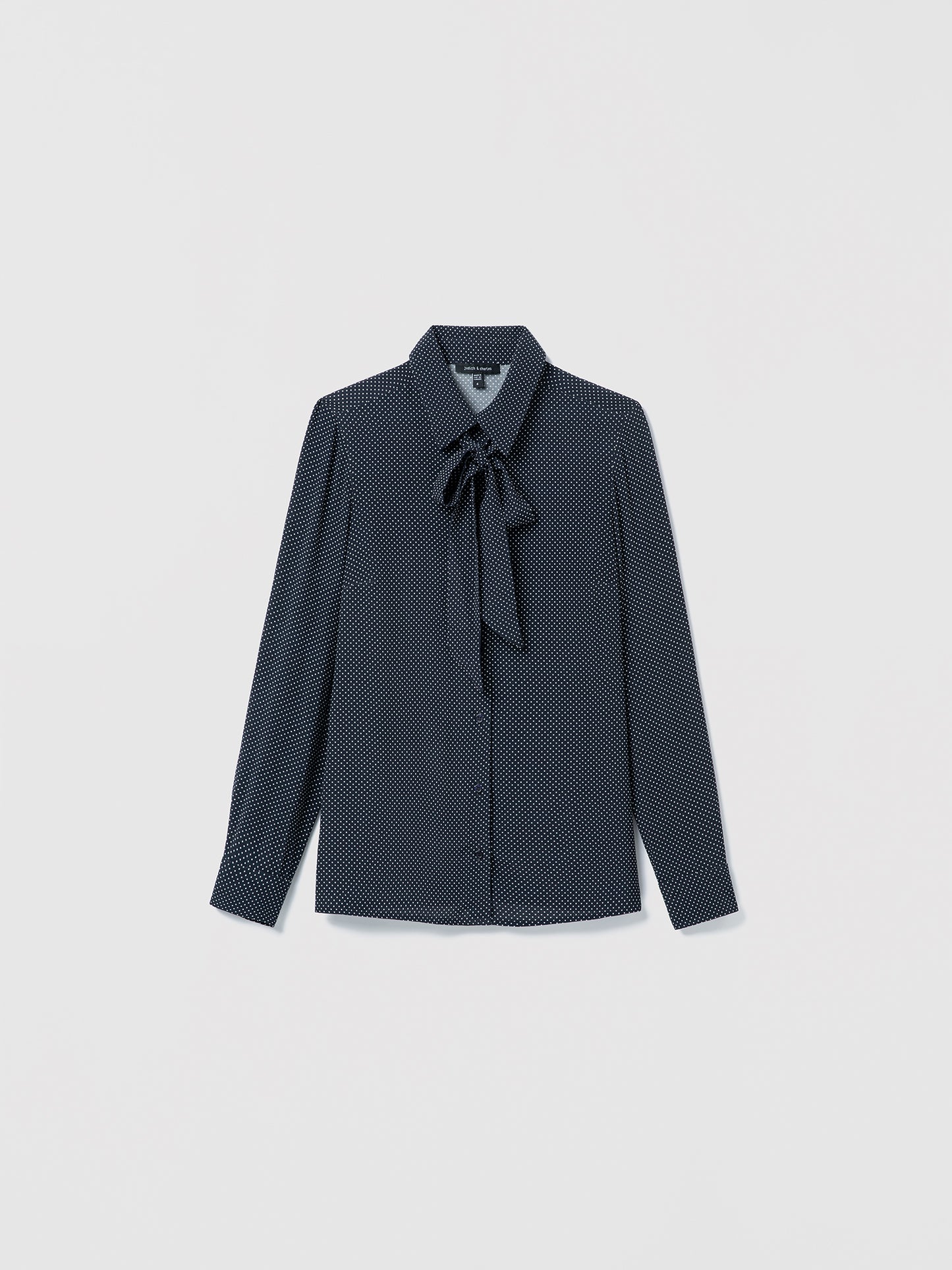 Navy off white patterned blouse with a tie detail on a light gray background