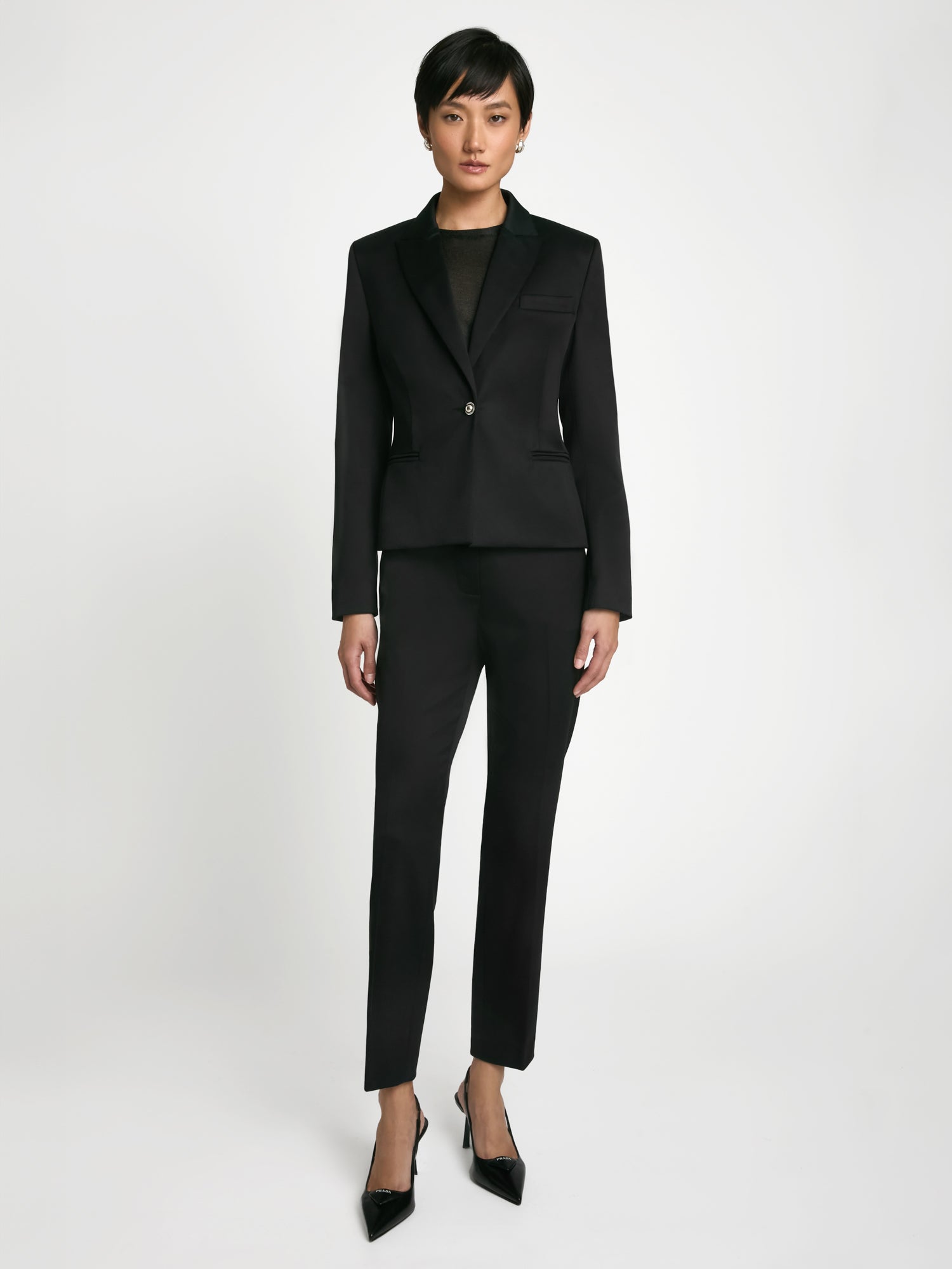 Woman wearing a Black tuxedo jacket by Judith and Charles with peak lapels and jewel button closure