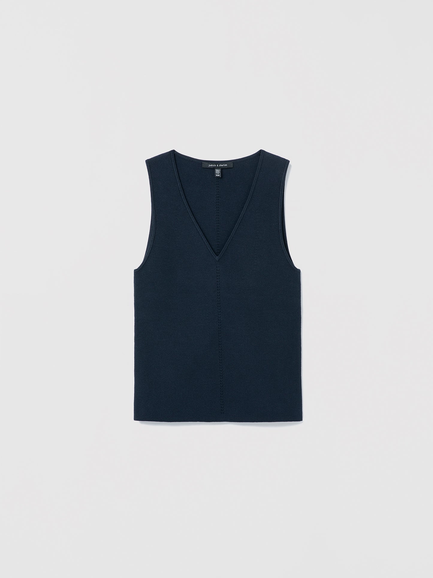 Flat‑lay of a navy V‑neck silk‑cotton shell with clean lines and minimalist finishing