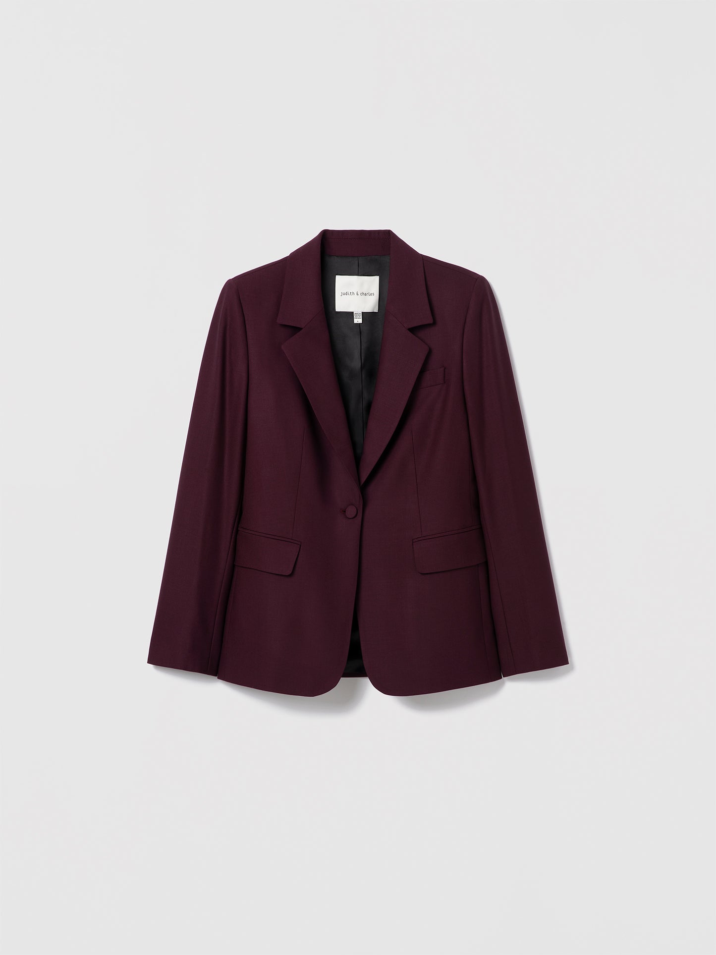 Dark Cherry structured virgin wool-blend jacket by Judith & Charles, with a notch lapel, flap pockets, self-covered buttons, and a single back vent. Fully lined.